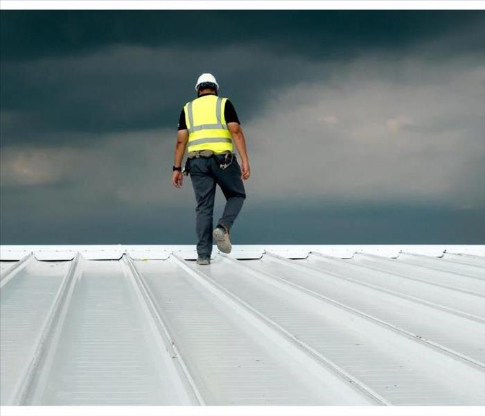 Construction engineer wearing safety uniform inspection metal roofing work for roof industrial