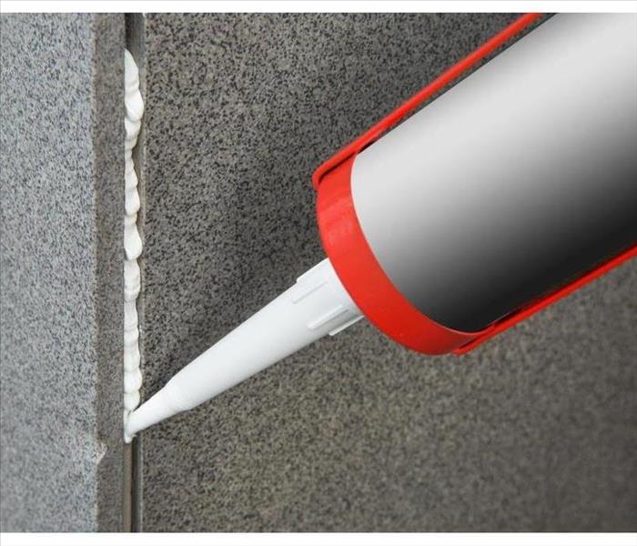 Sealant gun crack covers the crack in the floor of the wall tile concrete